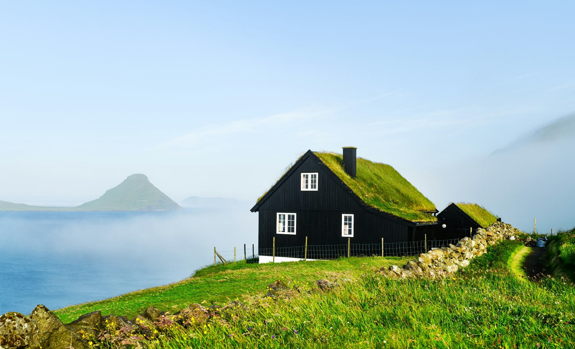 Black wooden faroese house with turf-top grass roof