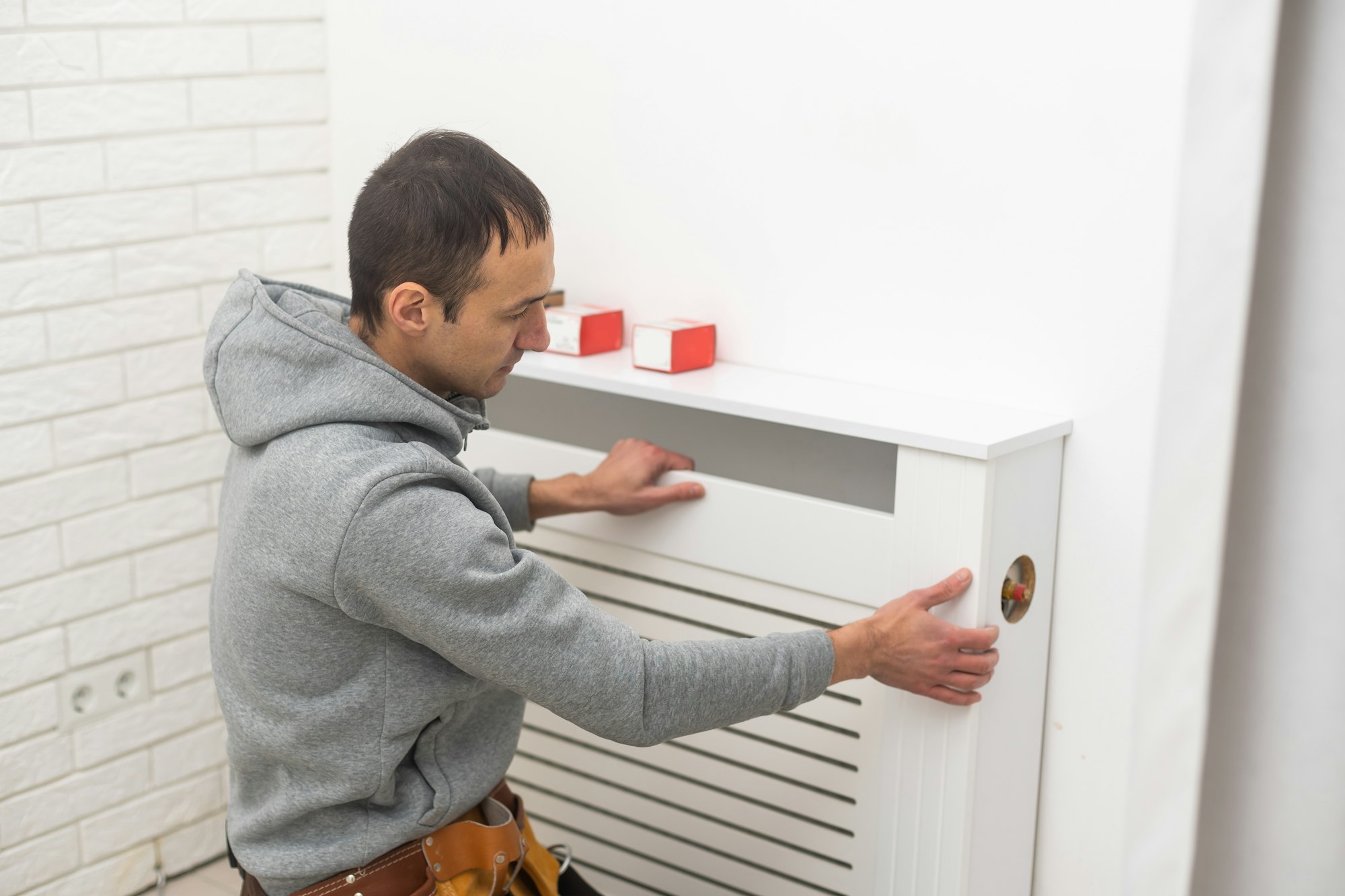 repairman using tools while installing or repairing heating radiator. plumber installing heating